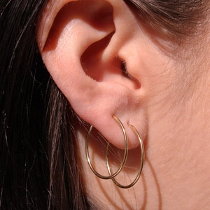 Créoles minimalistes en acier inoxydable doré de 15mm à 20mm portées sur le lobe d'oreille