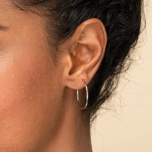 Créole élégante en acier inoxydable argenté sur un mannequin pour un look moderne épuré