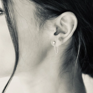 Minimalist stainless steel chain earring with zircon stud on female ear, side profile view
