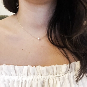 Minimalistische Edelstahlkette mit weißem Perlenanhänger an einer feinen goldenen Kette
