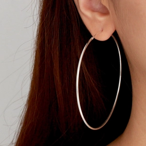 Grande boucle d'oreille créole minimaliste en acier inoxydable argenté sur un modèle
