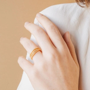 Close-up of a layered gold ring with sparkling pavé cubic zirconia on model finger