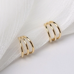 Macro view of triple-layered gold hoop earrings with a polished minimalist finish