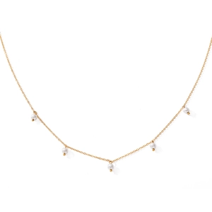 Detail of a thin gold chain necklace featuring five white imitation pearls evenly spaced
