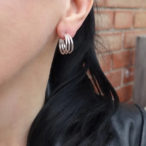 Macro shot of silver triple-layered curved C-shaped earrings with a polished metal finish