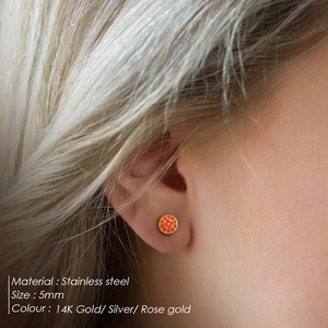 Boucles d'oreilles 5mm en acier inoxydable avec cristaux oranges sur un mannequin
