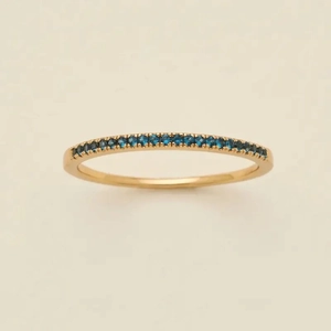 Macro view of gold-plated eternity ring with pave set round blue zircon stones