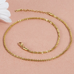Gros plan du collier en acier inoxydable doré avec texture torsadée et fermoir sur fond rose