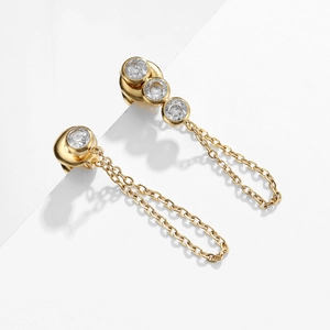 Detail of gold tassel earrings with triple round zircons and delicate chain fringe