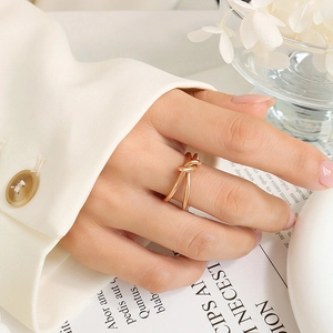 Gros plan d'une bague nœud en acier inoxydable doré au doigt avec un fond de style de vie