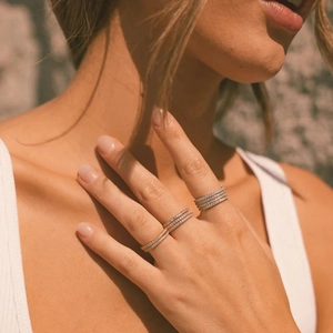 Detail of stacked thin diamond rings in 18K gold plating worn on a model's hand