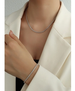 Détail d'un ensemble collier et bracelet tennis étincelants en acier sur un mannequin