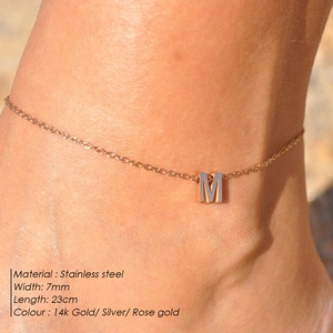 Detailed view of golden stainless steel anklet with letter M pendant worn on ankle