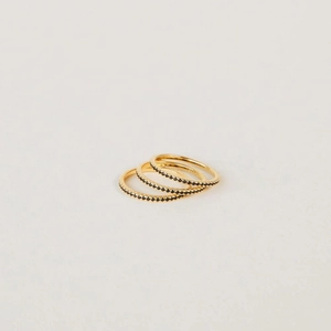 Macro shot of three stacked gold plated eternity rings with pave black zircon stones