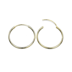 Boucles d'oreilles créoles dorées en acier inoxydable poli sur fond blanc