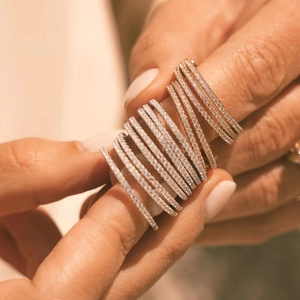 Close-up of stacked rose gold and gold thin pavé diamond rings with zircon stones
