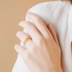 Close-up of a delicate 18K gold ring with double rows of sparkling cubic zirconia