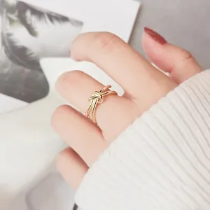 Bague double anneau doré avec nœud minimaliste portée par un mannequin sur la main