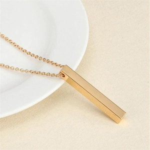 Detailed view of a polished gold minimalist rectangular pillar pendant on a fine chain