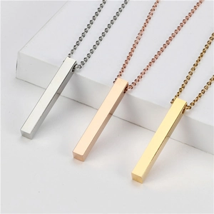 Macro shot of minimalist vertical bar pendants in silver, gold, and rose gold finishes