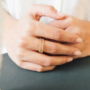 Close-up of three gold-plated stainless steel rings with sparkling cubic zirconia pavé