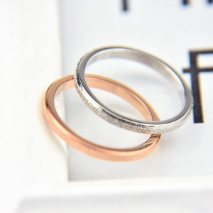 Macro detail of minimalist rings showing rose gold polished and silver frosted finishes
