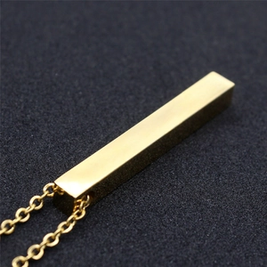 Macro view of a polished gold rectangular vertical bar pendant on a stainless steel chain