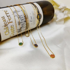 Detailed display of four gold-plated round pendants with colorful crystals on a silk background
