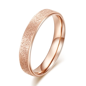 Close-up of rose gold stainless steel ring with frosted texture and polished inner surface