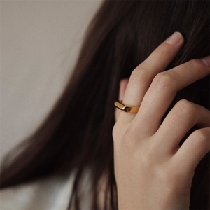 Detailed close-up of a minimalist gold-plated stainless steel ring with a geometric cut