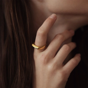 Close-up of a minimalist gold-plated stainless steel geometric ring worn by a model