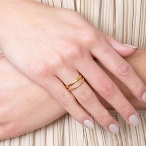 Close-up of minimalist double-layer gold stainless steel adjustable rings on model