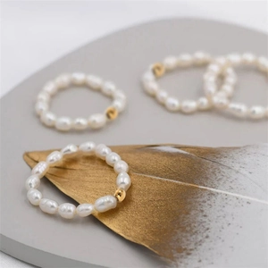 Minimalist stainless steel ring with baroque pearls and gold beads on elegant display