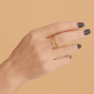 Close-up of golden double-layer adjustable stainless steel ring worn on finger