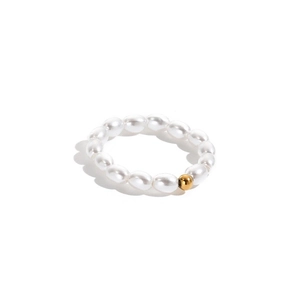 Detail shot of oval pearl ring with a polished gold bead on minimalist elastic band