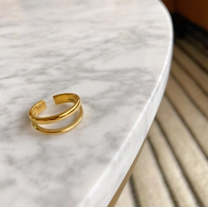 Detail of gold double-layer adjustable ring with polished and matte stainless steel finish