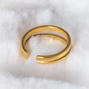 Close-up of golden double-layered adjustable stainless steel ring on white faux fur