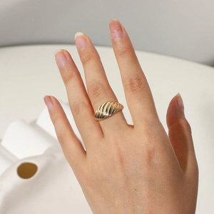 Détail de la bague croissante dorée montrant la texture vintage torsadée au doigt