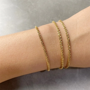 Close-up of three-layer gold-plated stainless steel chain bracelets with sparkling texture