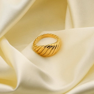 Vue détaillée d'une bague croissant torsadée plaquée or sur un élégant tissu en soie blanche