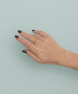 Detail of a minimalist gold oval chain link ring worn on a finger for a chic look