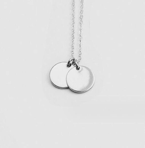 Detail of minimalist stainless steel necklace with dual smooth round disc pendants