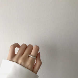 Close-up of minimalist silver stainless steel ring worn on finger with a daily wear look