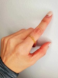 Macro shot of minimalist gold plated oval link chain ring worn on finger