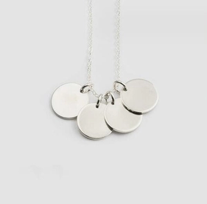 Detail view of a minimalist silver stainless steel chain with four round smooth disc pendants