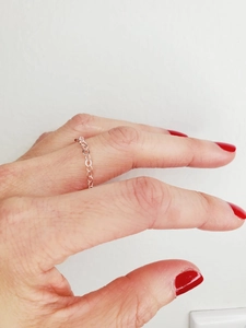 Close-up of rose gold plated chain ring with oval links worn on female finger