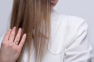 Close-up of minimalist geometric stainless steel ring on finger with polished finish