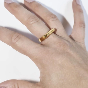 Close-up of a gold-plated stainless steel ring with a flat geometric rectangular surface