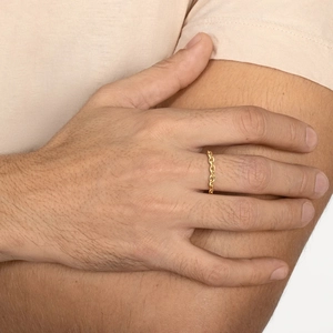 Close-up of a gold-plated stainless steel link ring with oval facets worn on a finger