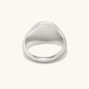 Detailed view of a polished silver signet ring with a minimalist smooth round surface